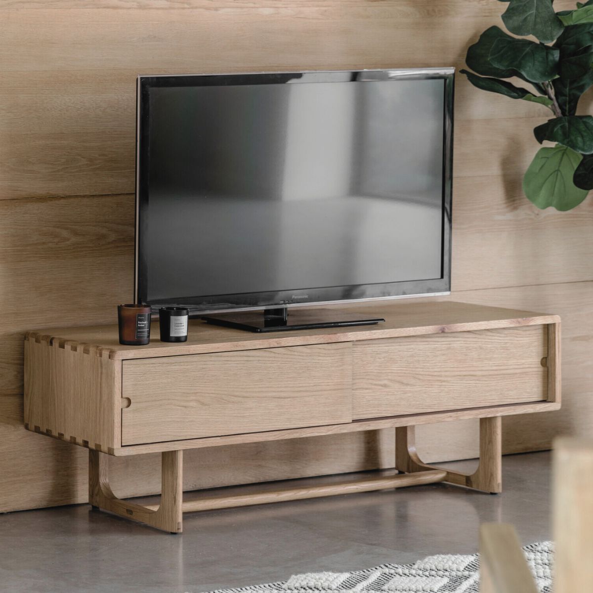 Artisan oak media unit with sliding doors and shaped underframe in natural finish | malletandplane.com